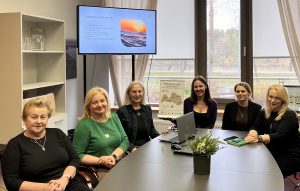 Sešas sievietes sēž pie galda Ādažu novada pašvaldības telpā diskusijas laikā par remigrāciju un uzņēmējdarbību